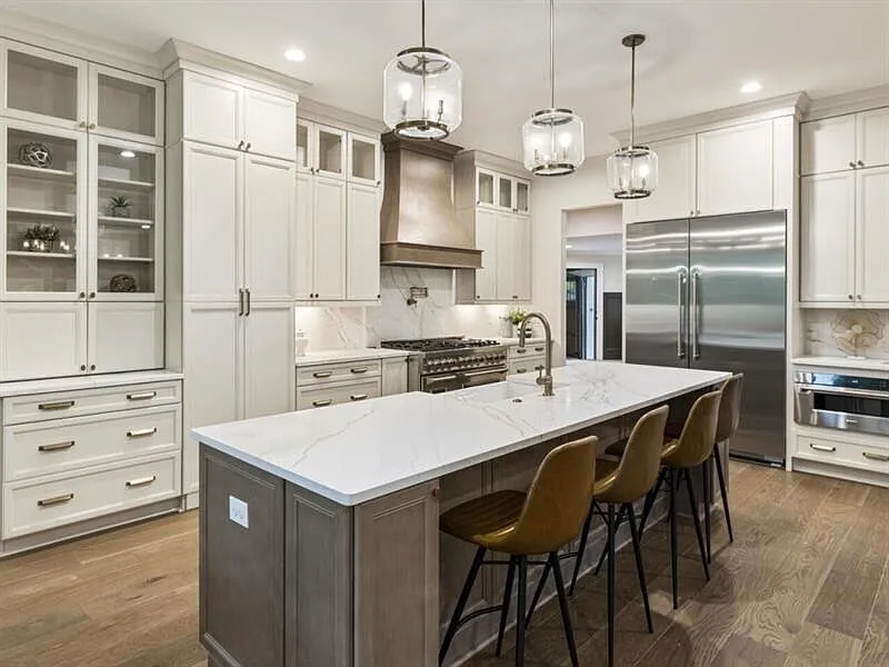 Bright luxury kitchen with oversized marble island and custom cabinetry
